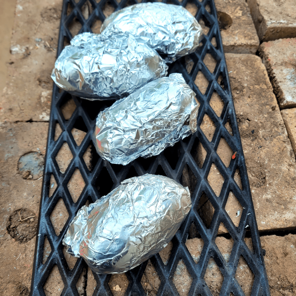 Image illustrates an off-grid rocket stove cooking potatoes. 