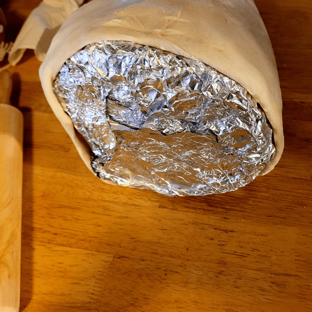 Image illustrates aluminum foil cornucopia mold showcasing a Thanksgiving breaded cornucopia recipe. 