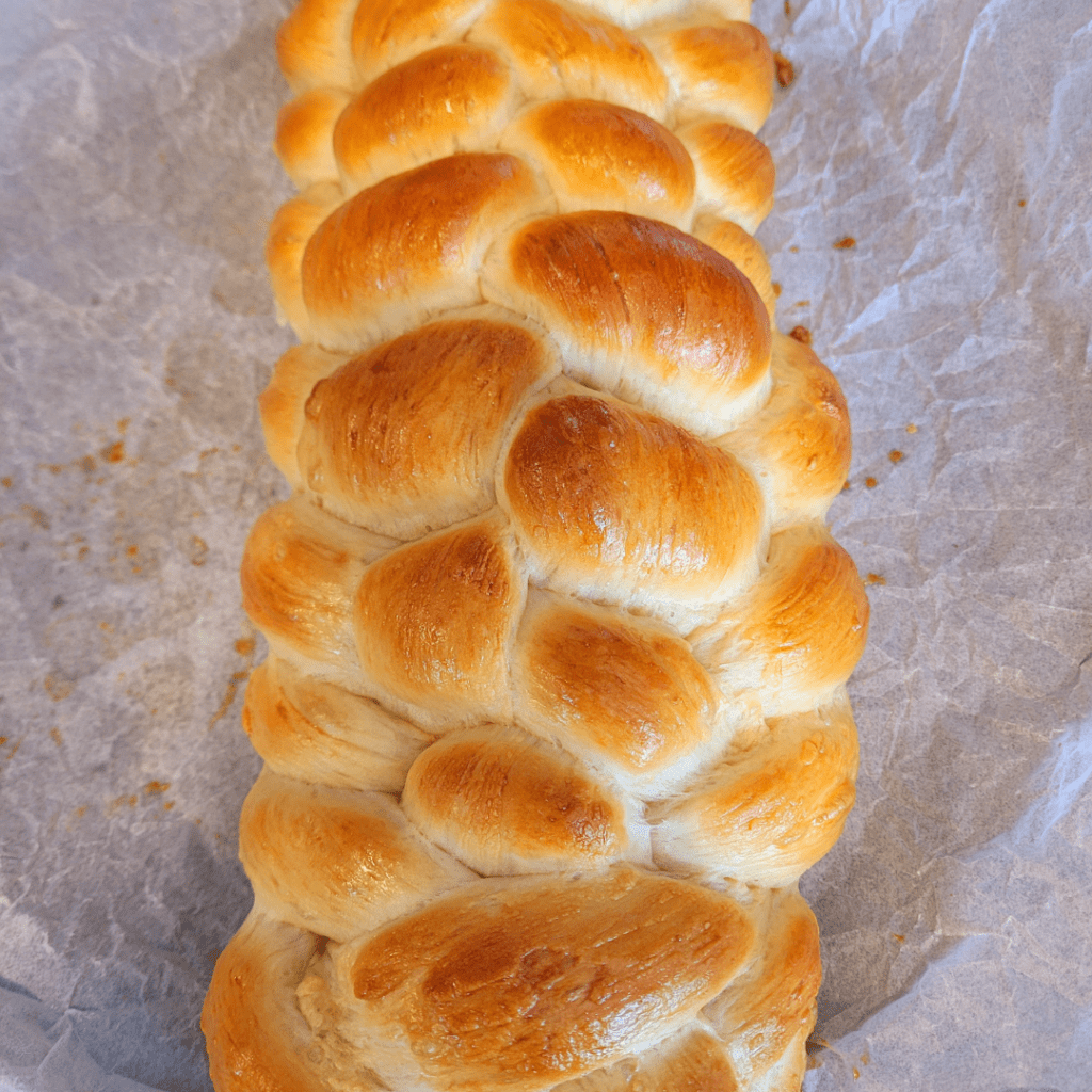 Image illustrates a 6 braided challah bread.