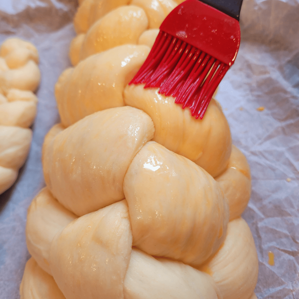 Image illustrates a 6 braided challah bread demonstrating how to braid a challah bread.