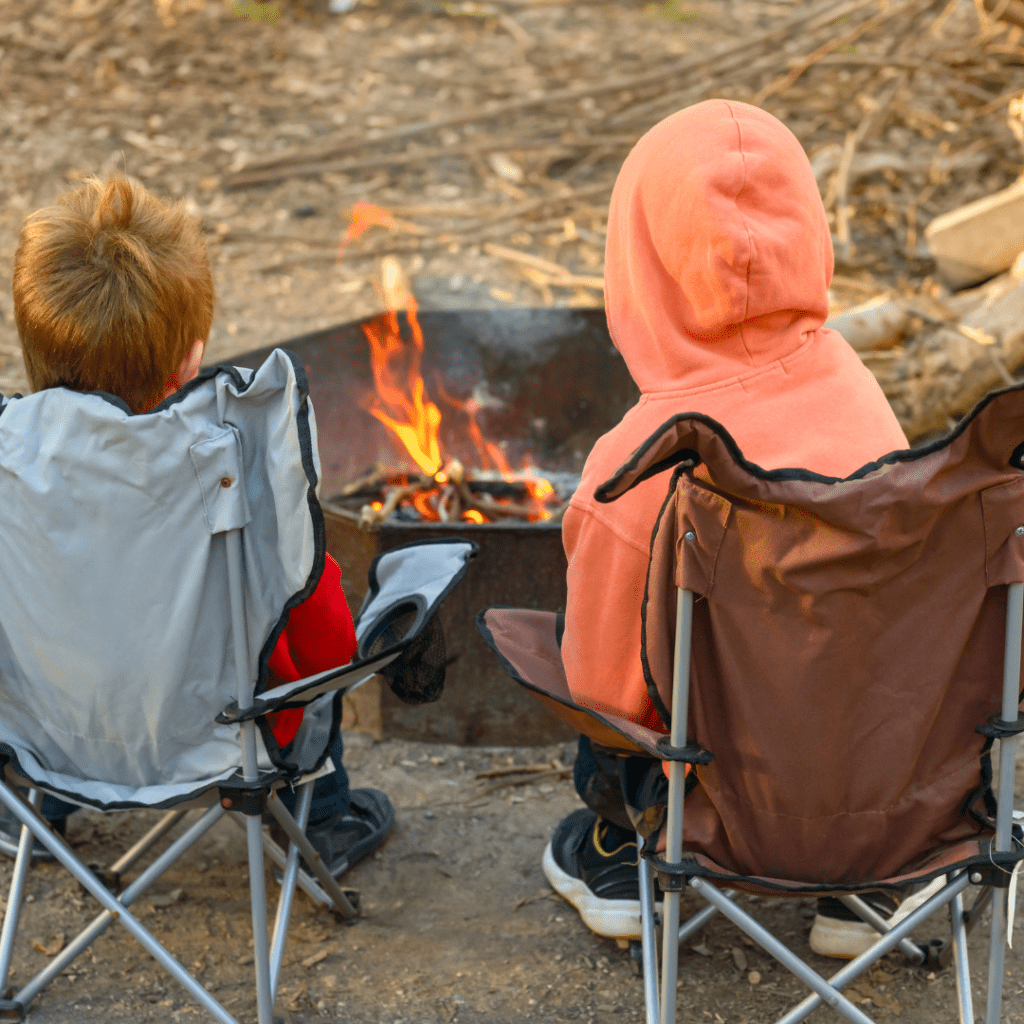 Image illustrates kids around a campfire for campfire safety for kids.