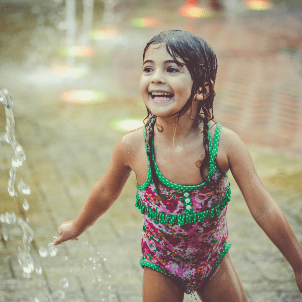 Image illustrates free summer boredom busters for kids like a backyard splash pad.
