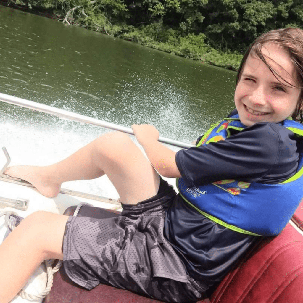 Image illustrates an image of a kid on a boat for lake fishing with kids.