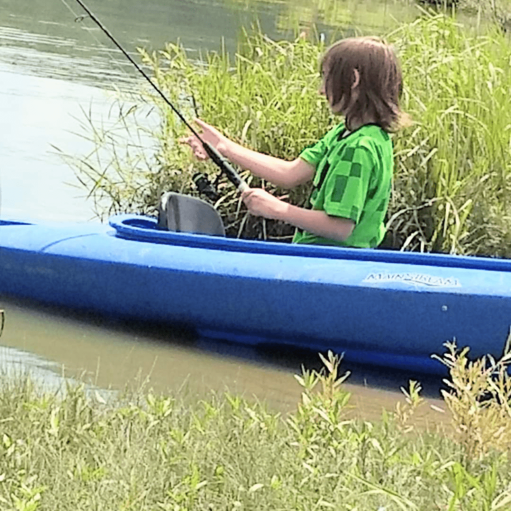 Image illustrates an image of a kid fishing in a kayak.