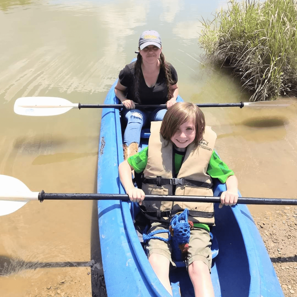Image illustrates an image of a woman and a kid in a kayak.