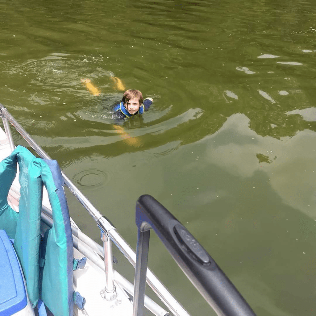 Image illustrates an image of a kid swimming in a lake.