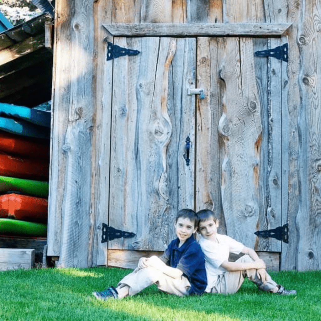Image illustrates an image of a kids posing with kayaks.