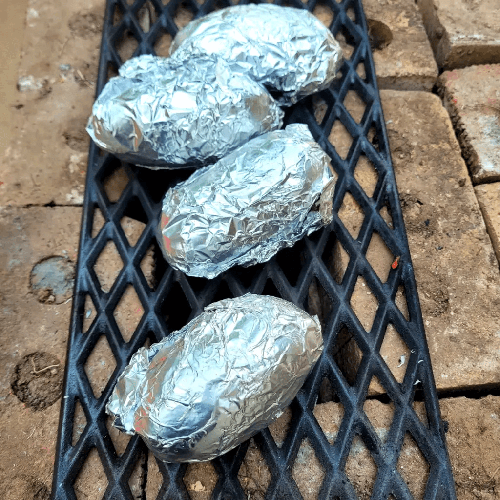 Image illustrates an off-grid rocket stove cooking potatoes. 

