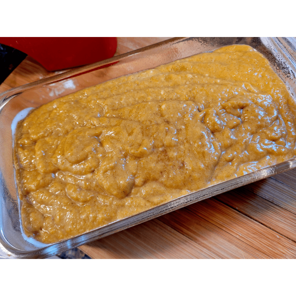 Image illustrates pumpkin bread batter in a greased pan for a pumpkin bread recipe.