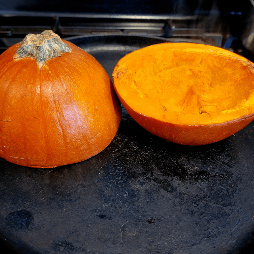 Image illustrates a sugar pumpkin sliced in half for a pumpkin bread recipe.