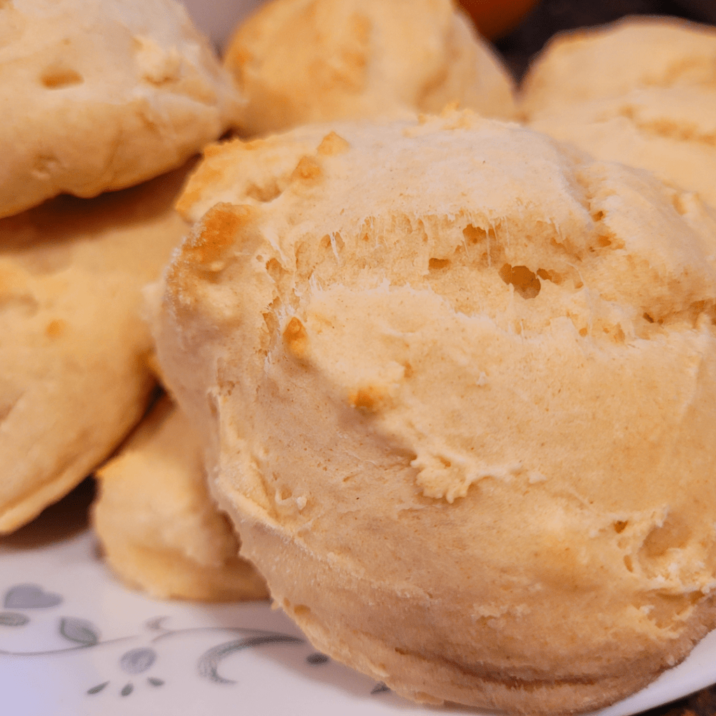 Image illustrates a plate of biscuits for a sourdough buttermilk drop biscuits recipe tutorial.