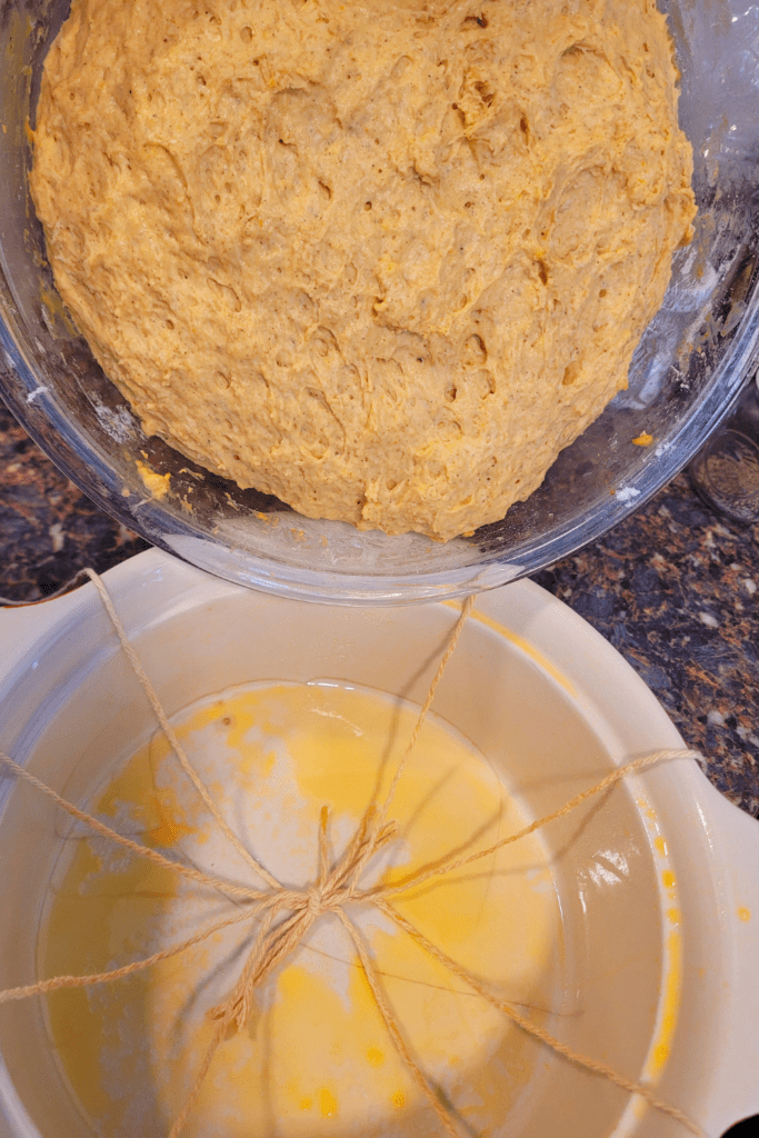Image illustrates dough ready to be placed over cotton strings for a pumpkin-shaped sourdough bread recipe. 
