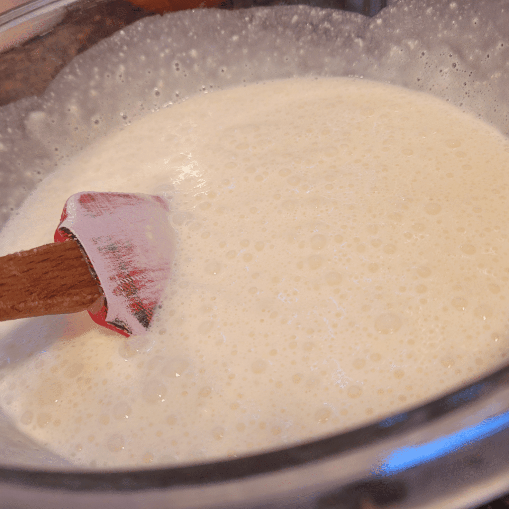 Image illustrates a mixing bowl of sourdough buttermilk drop biscuits batter.