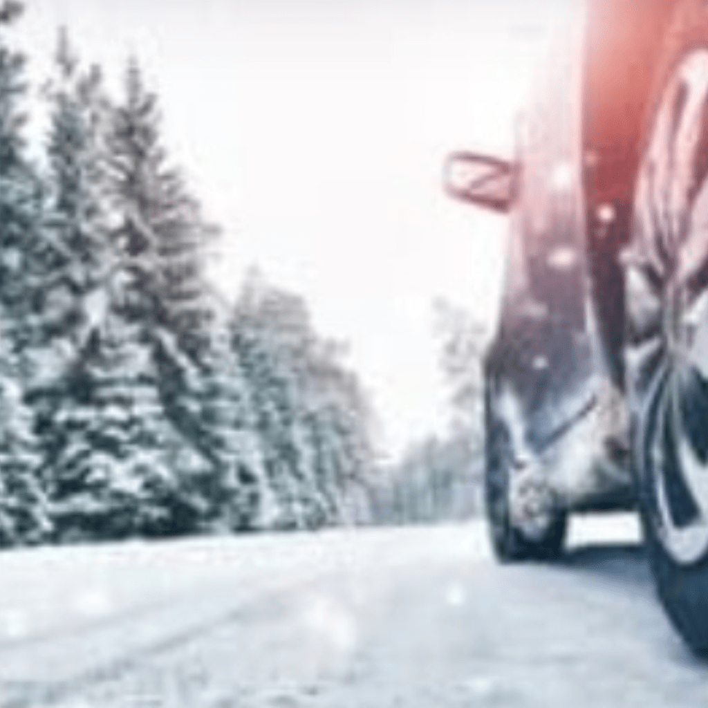 Image illustrates a car driving in a winter storm.