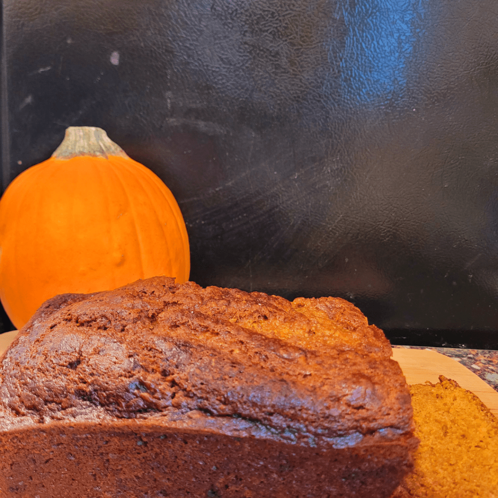 Image illustrates pumpkin bread with a pumpkin for a pumpkin bread recipe.