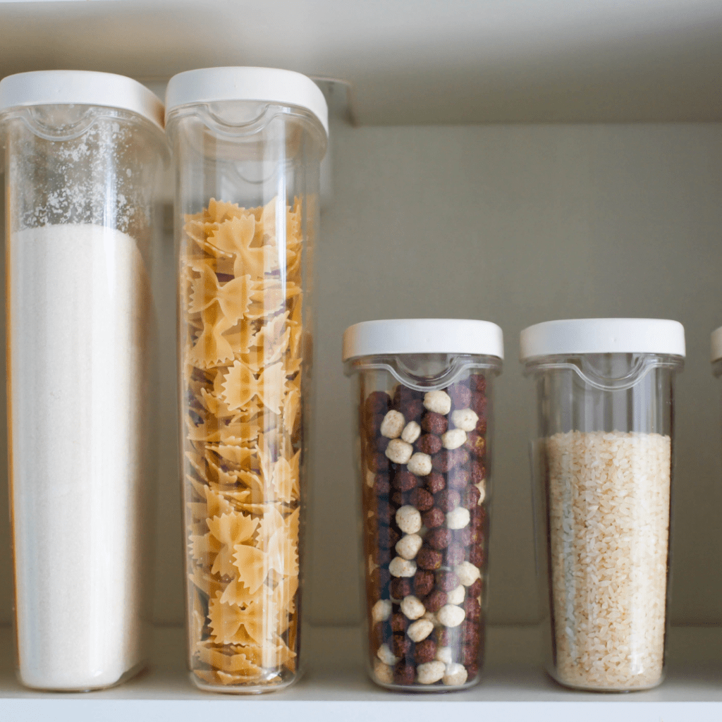Image illustrates organizing a pantry with plastic containers demonstrating how to get rid of moths in the pantry. 