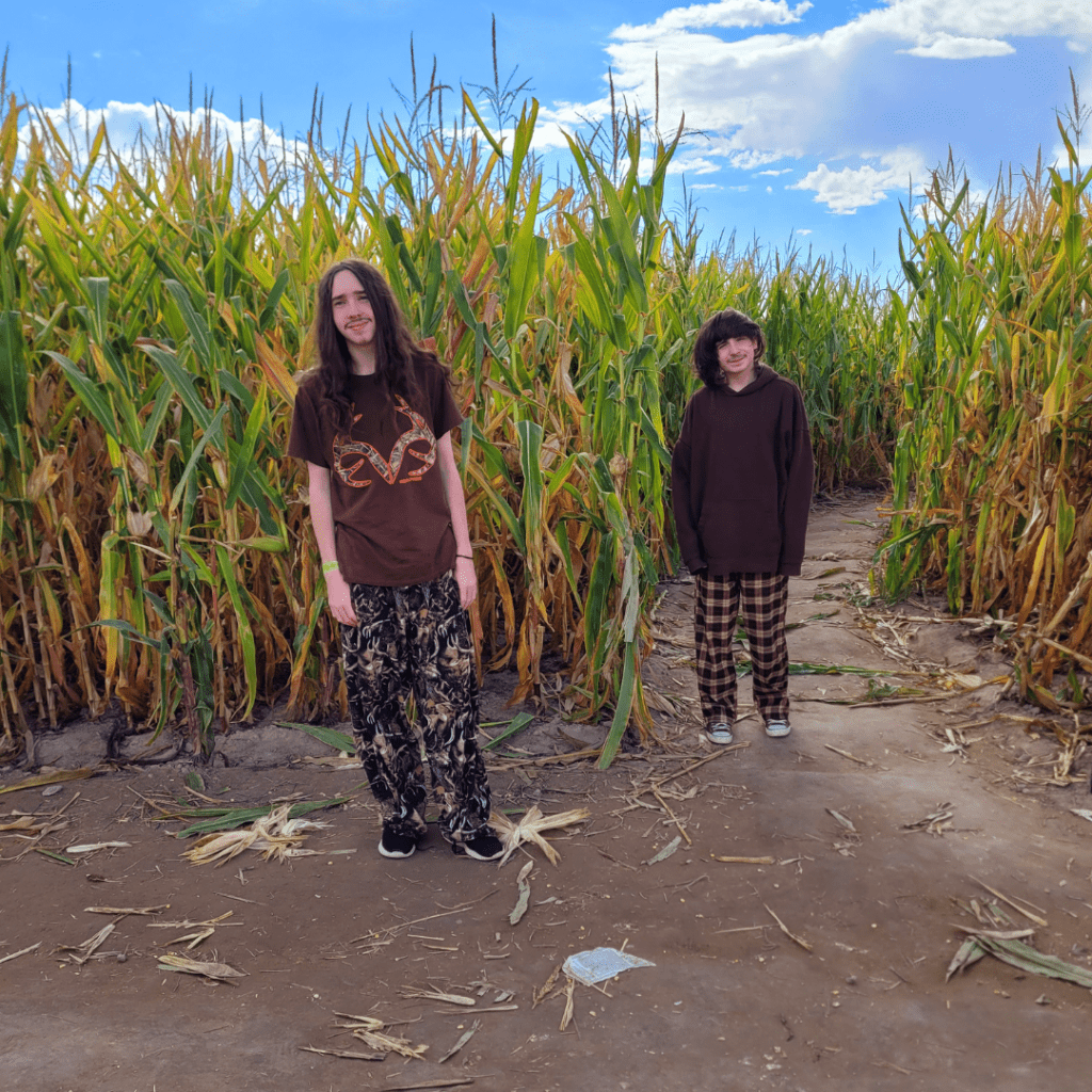 Image illustrates teens at a corn maze entrance.