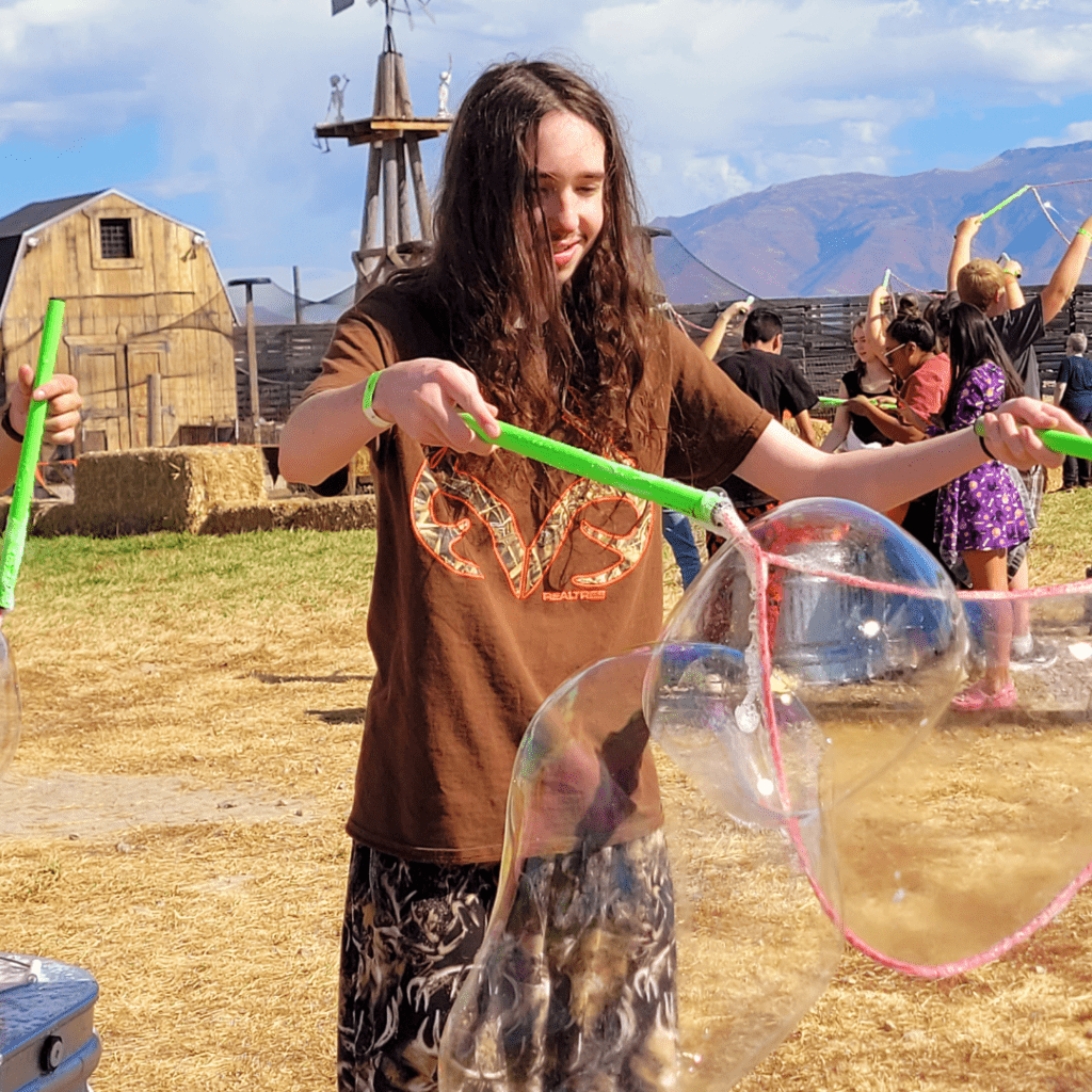 Image illustrates a boy with giant bubbles at a farm.