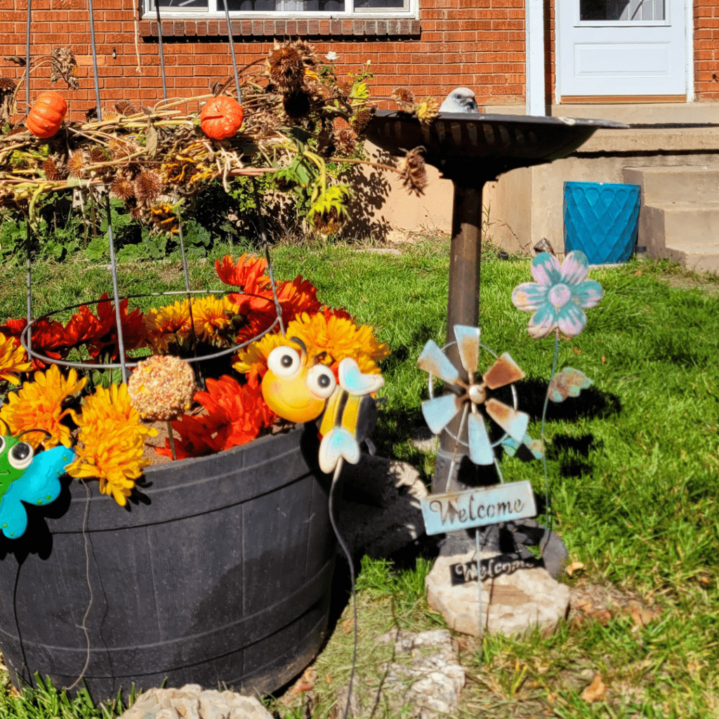 Image illustrates a bird feeder with a bird bath demonstrating how to make a bird feeder obelisk garden.