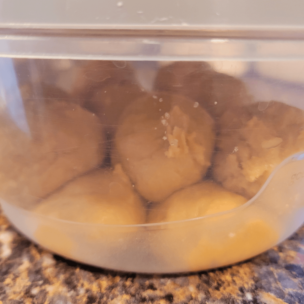 Image illustrates cookie dough in an airtight container. 