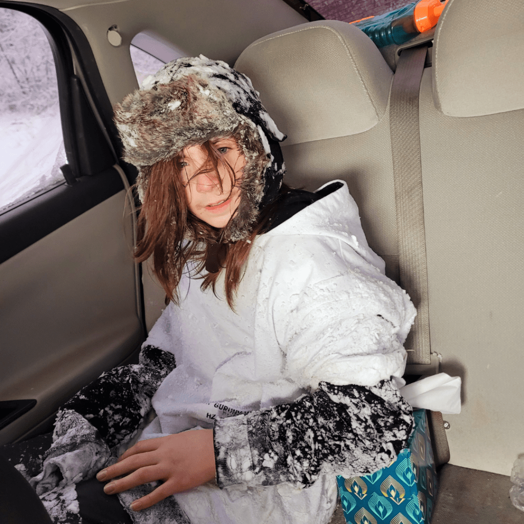 Image illustrates a teen boy covered in snow from mountain sledding demonstrating information on mountain sledding with teens. 