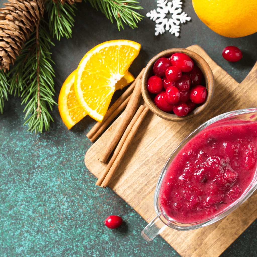 Image illustrates old-fashioned cranberry sauce with cinnamon sticks and orange slices. 