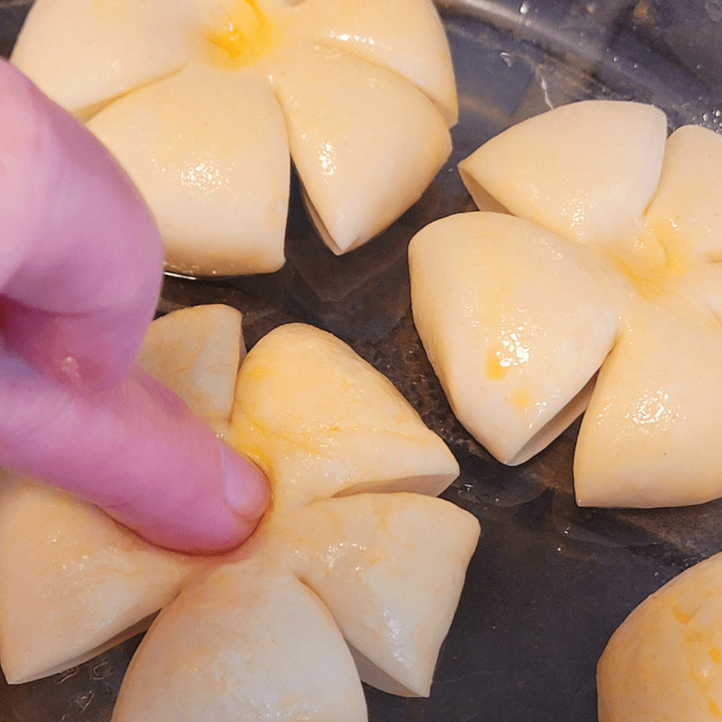 Image illustrates bread dough being shaped into pumpkins. 