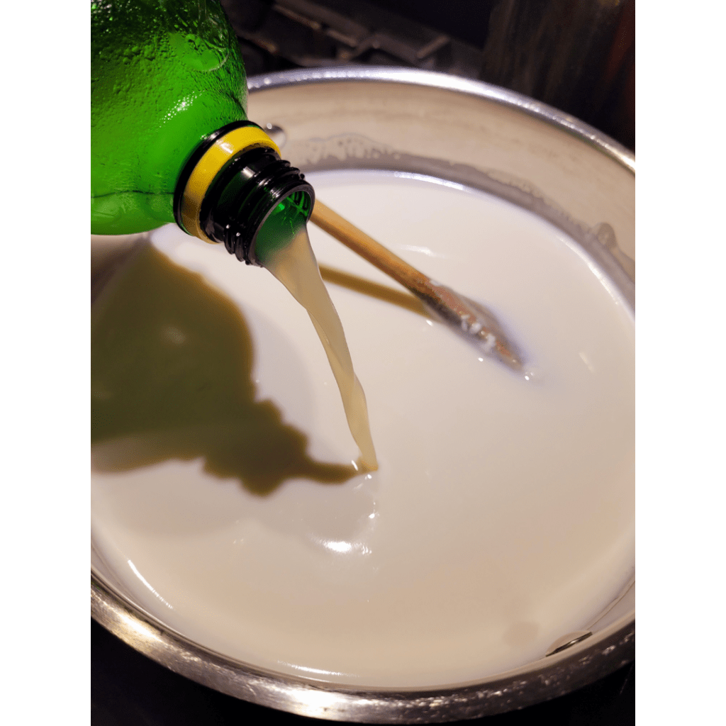 Image illustrates lemon juice being poured into whole milk demonstrating a recipe for easy homemade ricotta cheese. 
