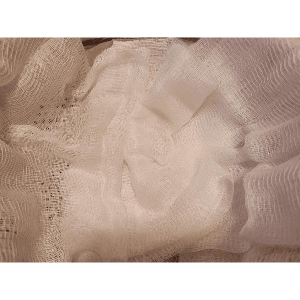 Image illustrates a cheesecloth to collect curdled whole milk demonstrating a recipe for easy homemade ricotta cheese. 