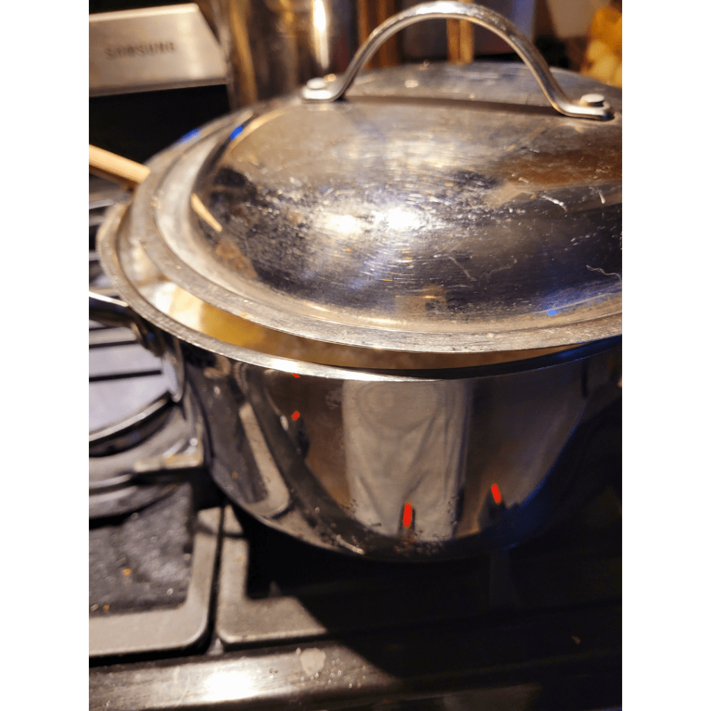 Image illustrates a pot of curdled whole milk demonstrating a recipe for easy homemade ricotta cheese. 