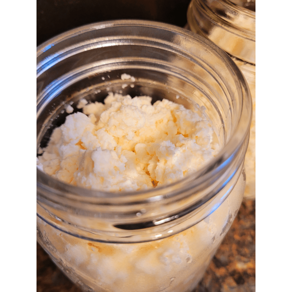 Image illustrates ricotta cheese in a Mason jar demonstrating a recipe for easy homemade ricotta cheese. 