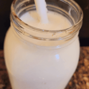 Image illustrates a jar of homemade cultured buttermilk.