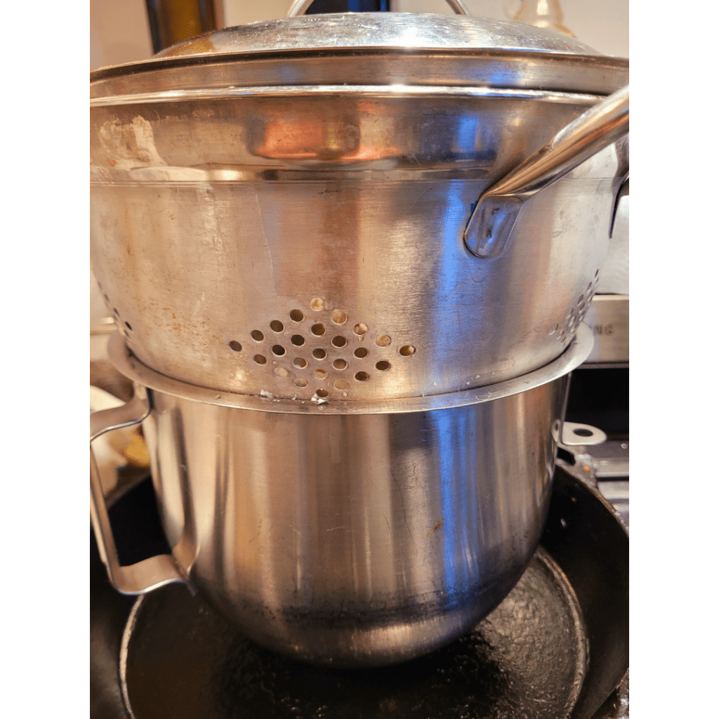 Image illustrates kitchen equipment such as a pot and strainer for an easy homemade ricotta cheese recipe. 