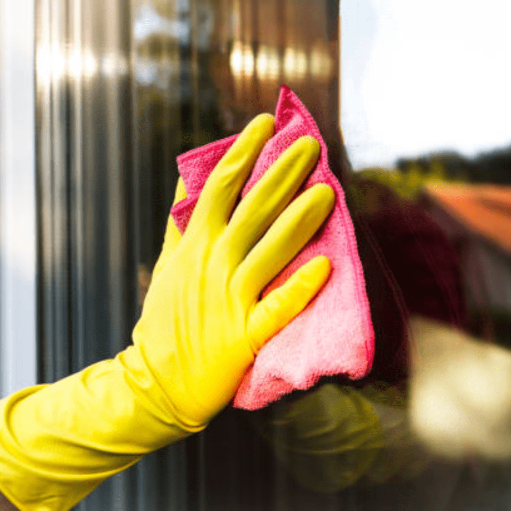 Image illustrates a person cleaning windows for spring cleaning. 