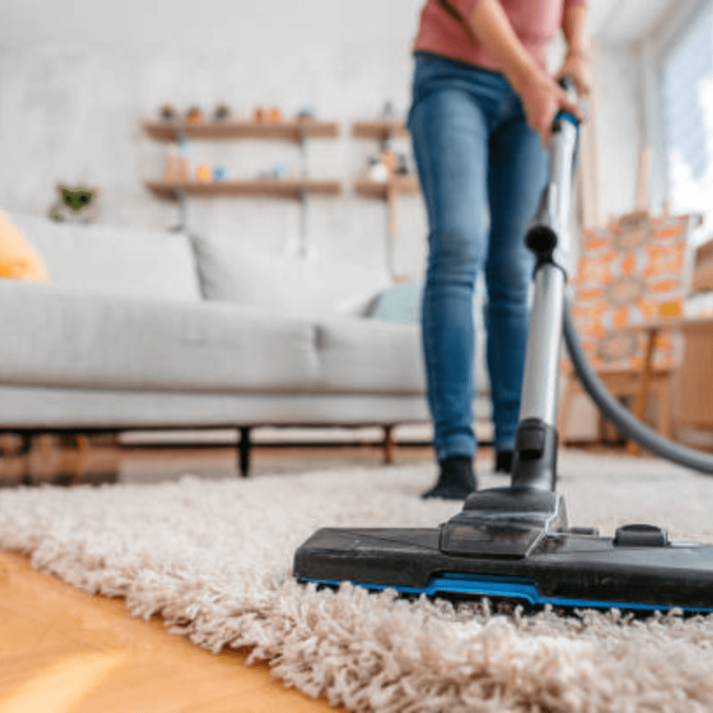 Image illustrates a person vacuuming for spring cleaning. 