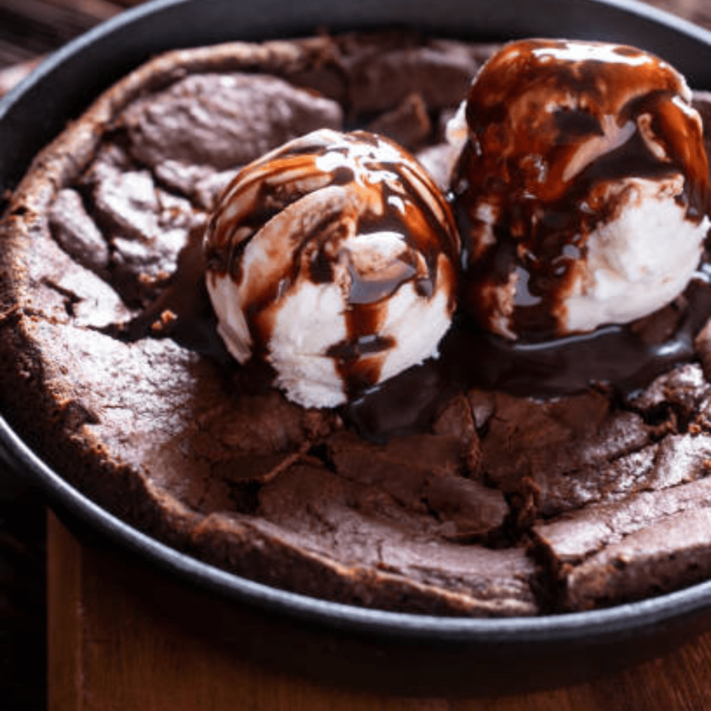 Image illustrates homemade brownies in a cast iron skillet. 