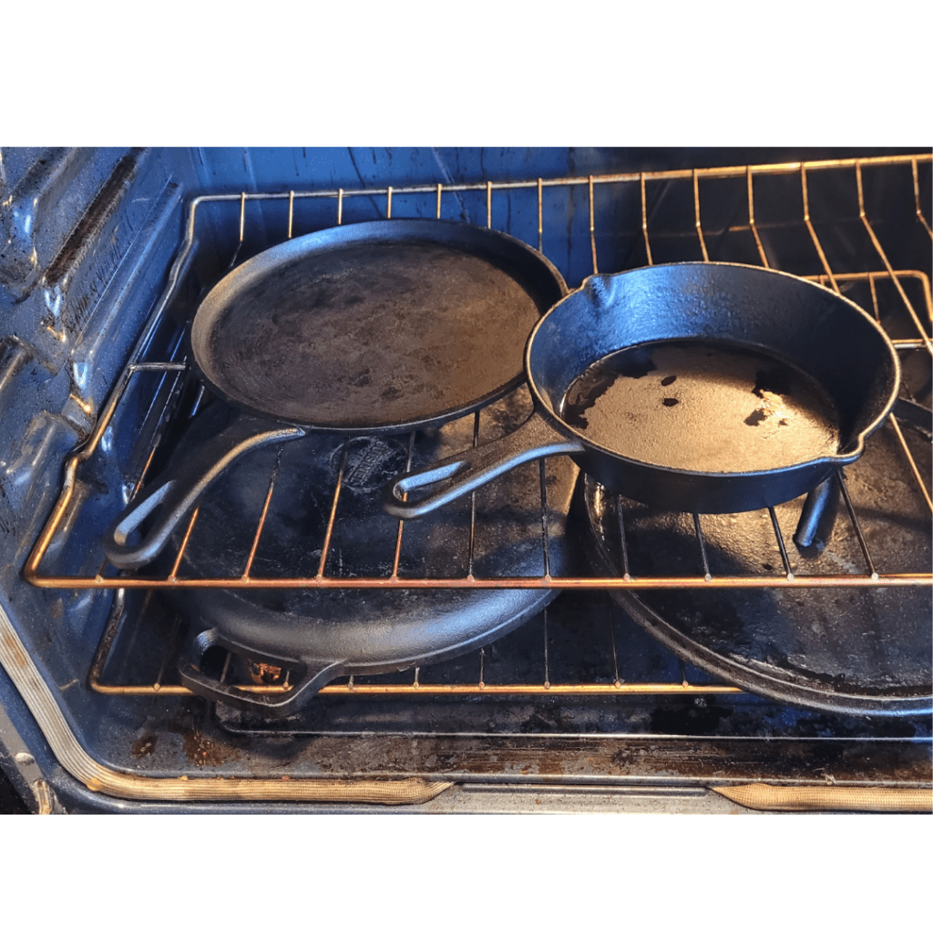 Image illustrates cast iron cookware being dried in the oven demonstrating how to season cast iron for cooking. 
