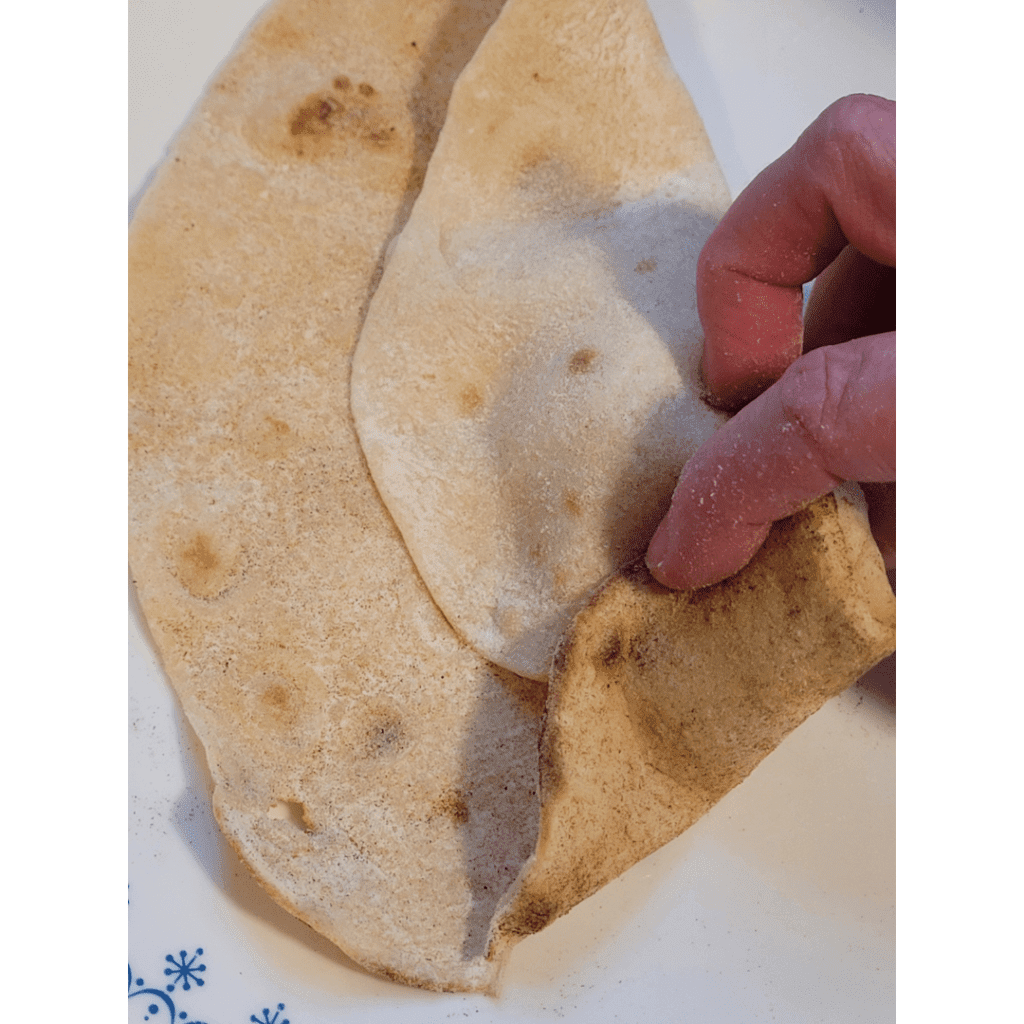 Image illustrates a person folding a tortilla.