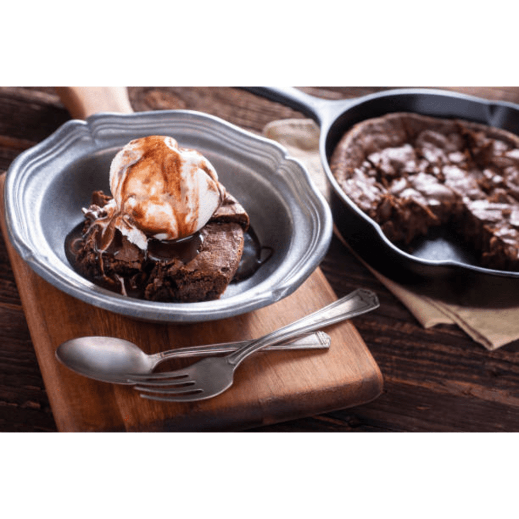 Image illustrates brownies with ice cream on a plate. 