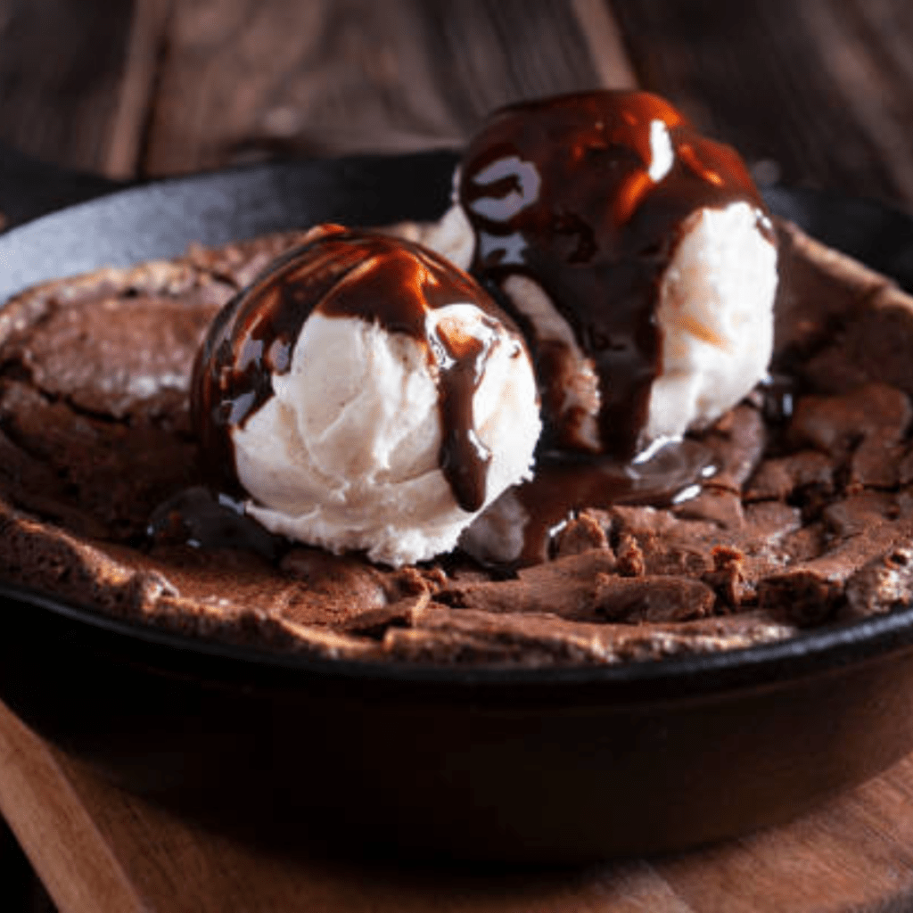 Image illustrates homemade brownies in a cast iron skillet.