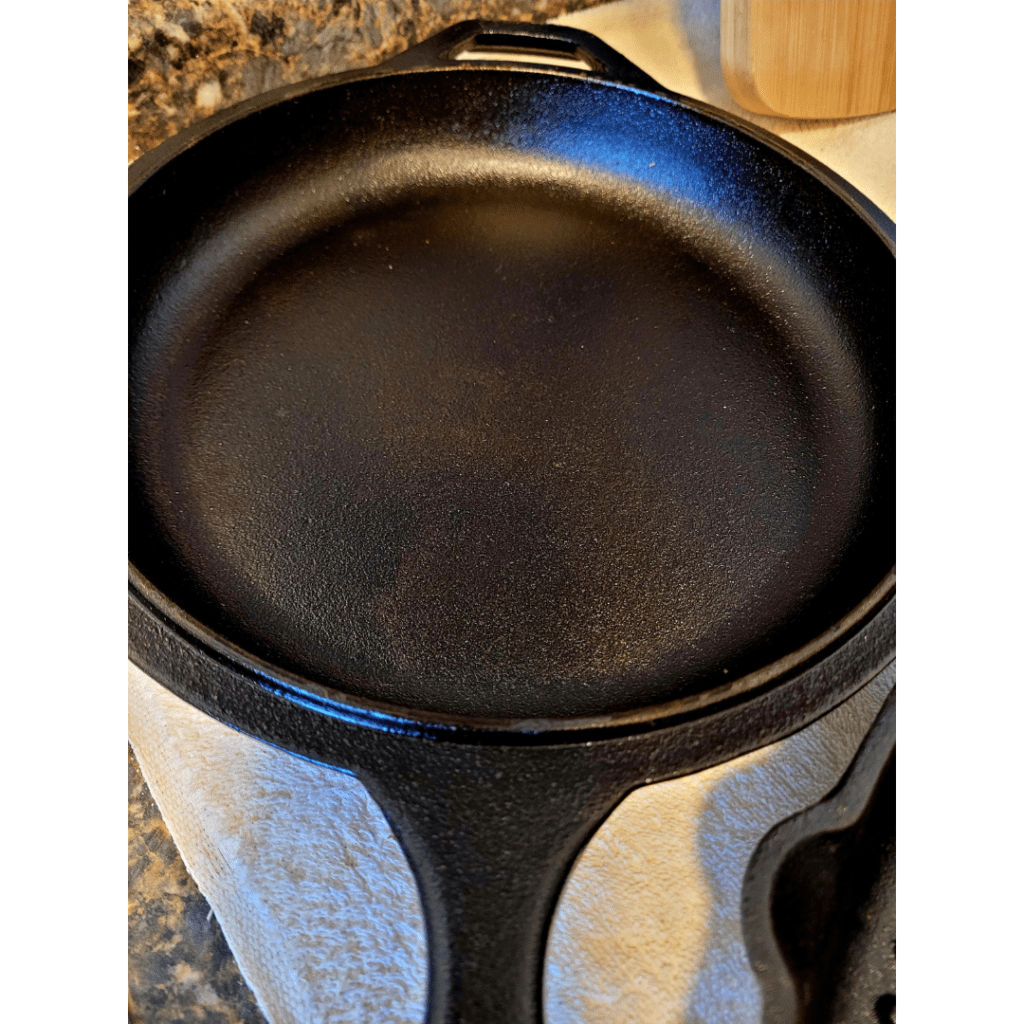 Image illustrates a seasoned cast iron pan demonstrating how to season cast iron for cooking. 