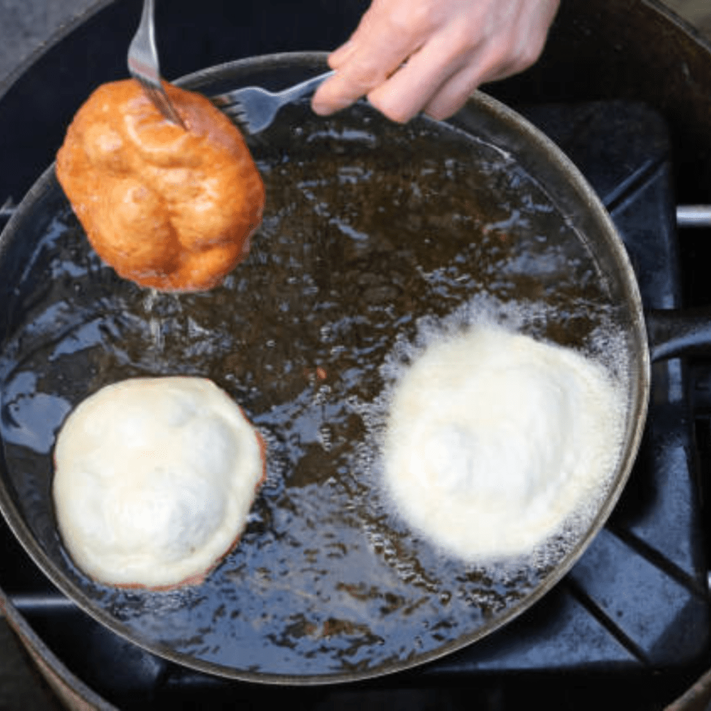 Image illustrates fry bread frying in a pan. 