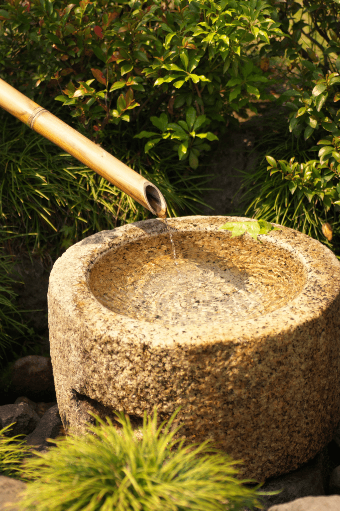 Image illustrates a water basin tsukubai in a Japanese tea garden.