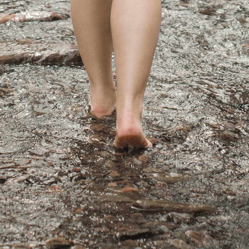Image illustrates barefoot in the river for barefoot grounding.