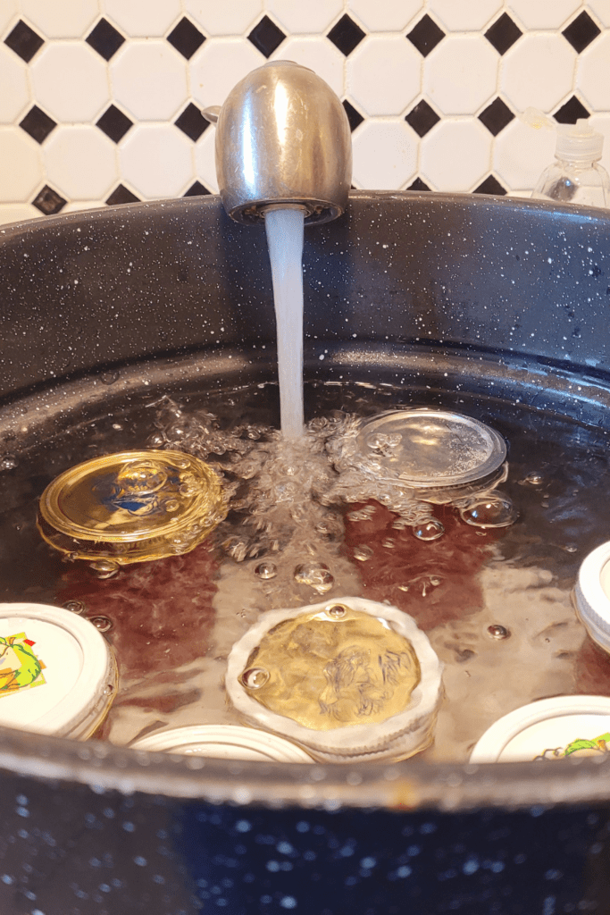 Image illustrates jars in a water bath canner. 