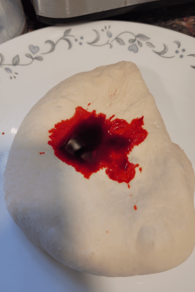 Image illustrates dough with red food coloring to make marbled bread.