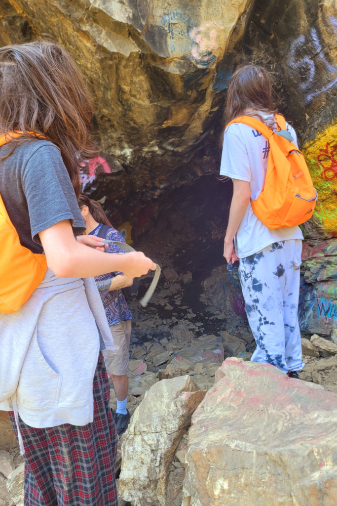 Image illustrates hikers in a cave.
