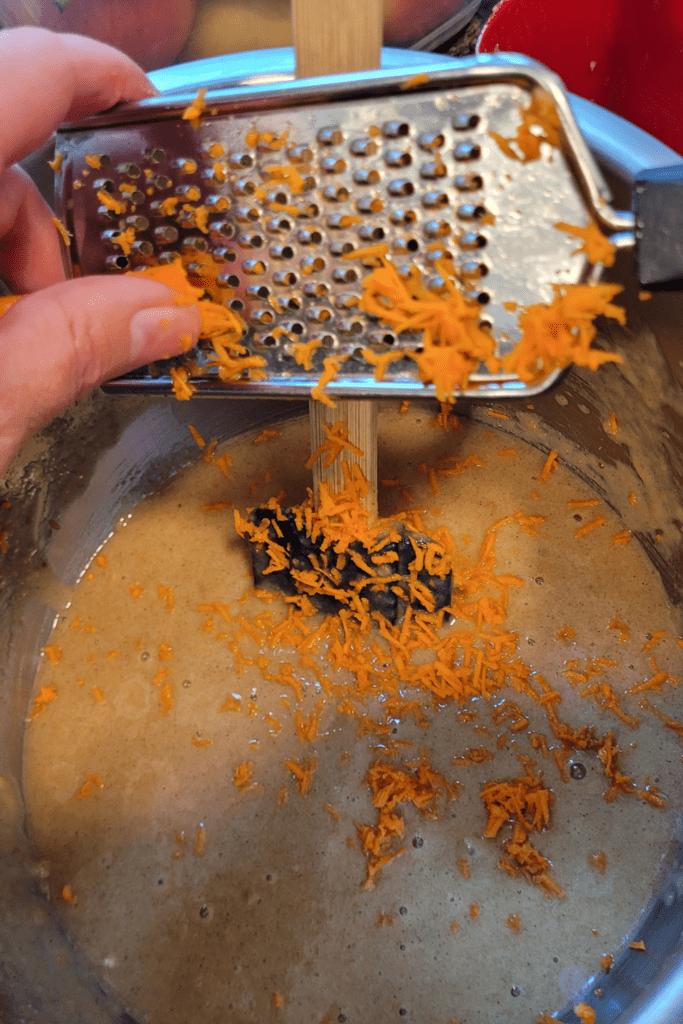 Image illustrates shredding carrots for carrot cake quick bread.