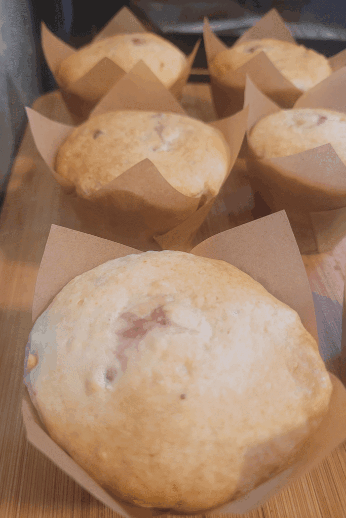 Image illustrates sourdough strawberry cheesecake muffins.