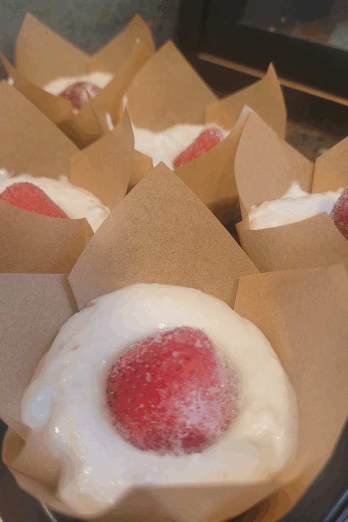 Image illustrates sourdough strawberry cheesecake muffins.